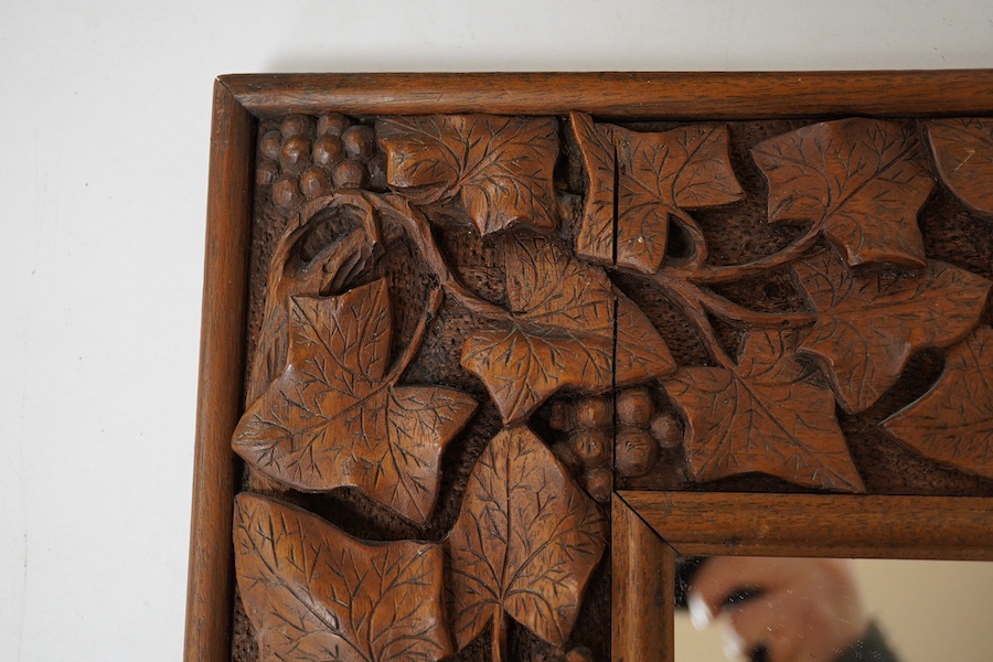 An early 20th century carved mahogany 'leaf, vine and berry' framed mirror, 41x38cm. Condition - good